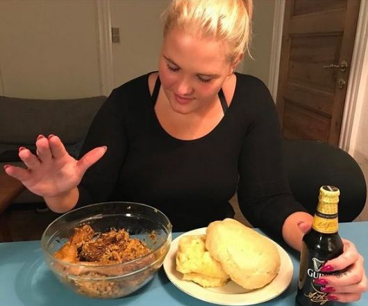 LOL! Oyinbo woman praying before eating Eba & Egusi with a bottle of Stout